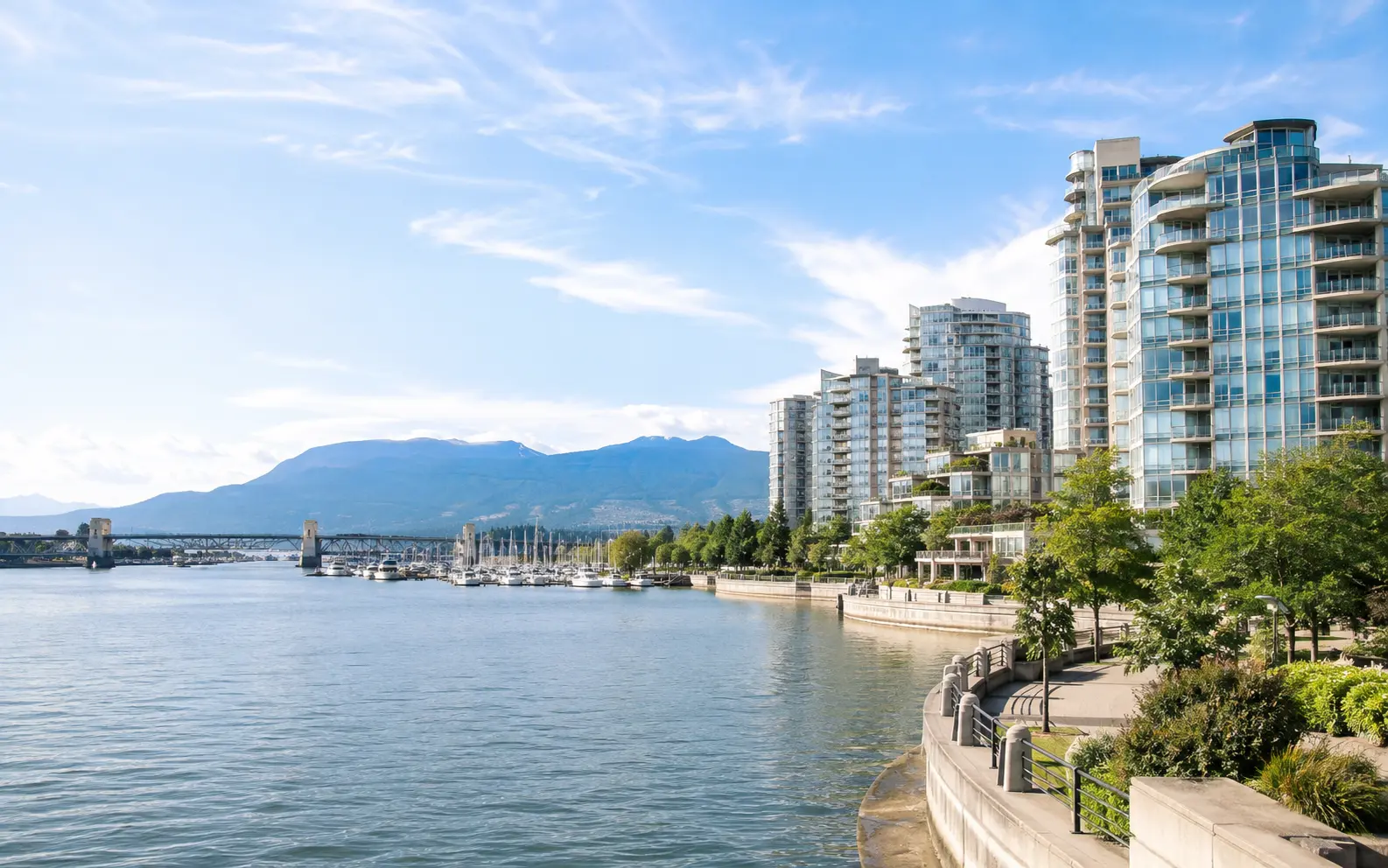 Sunny daytime view of Vancouver's False Creek waterfront under a bright blue sky